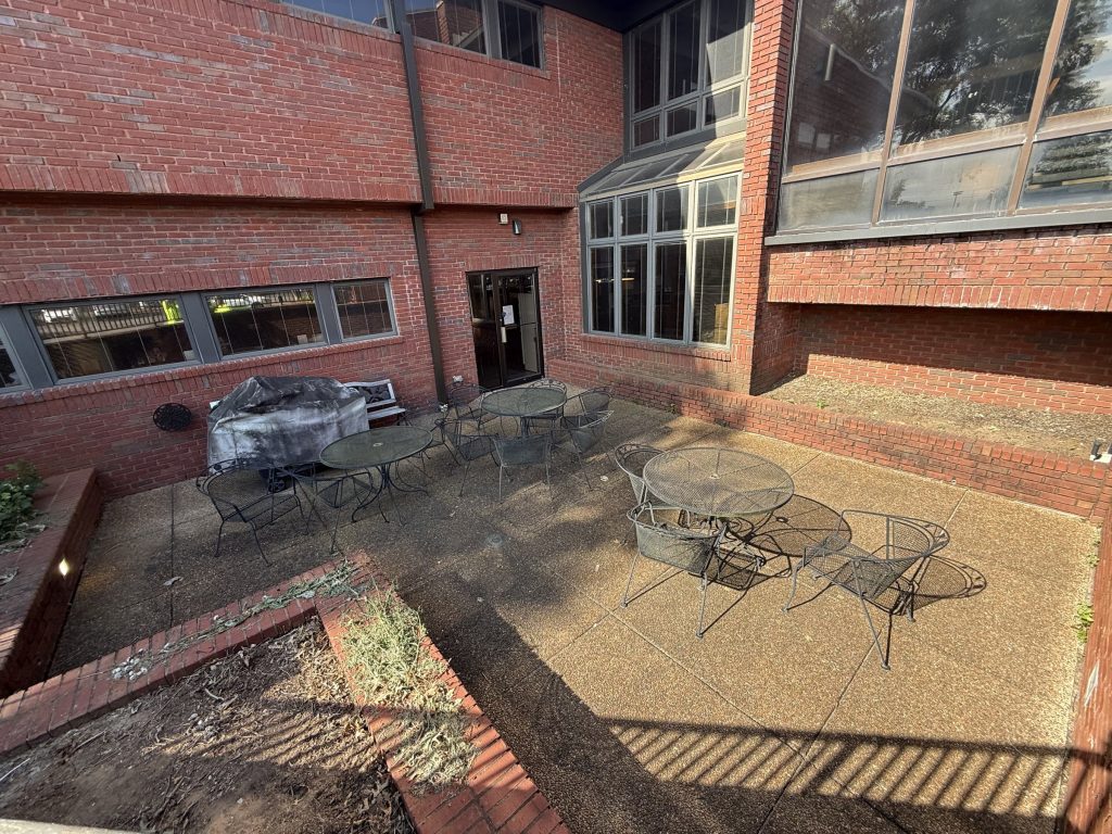 Employee patio aggregate concrete before cleaning, dirty and stained, at Hospice Family Care in Huntsville, AL